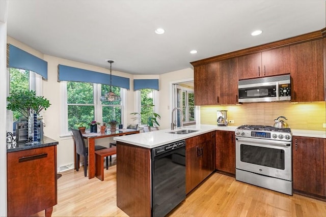 8963 Seneca Ave, Mccandless, PA 15237 - kitchen featuring appliances with stainless steel finishes, a sink, a peninsula, light wood-style flooring, and tasteful backsplash