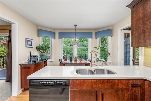 8963 Seneca Ave, Mccandless, PA 15237 - kitchen with black dishwasher, a sink, hanging light fixtures, light wood-style floors, and baseboards