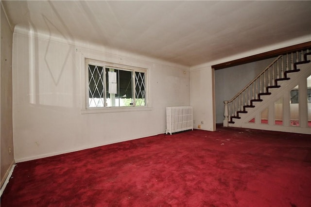 4605 2nd St, Versailles Boro, PA 15132 - unfurnished living room featuring radiator heating unit, stairs, and carpet