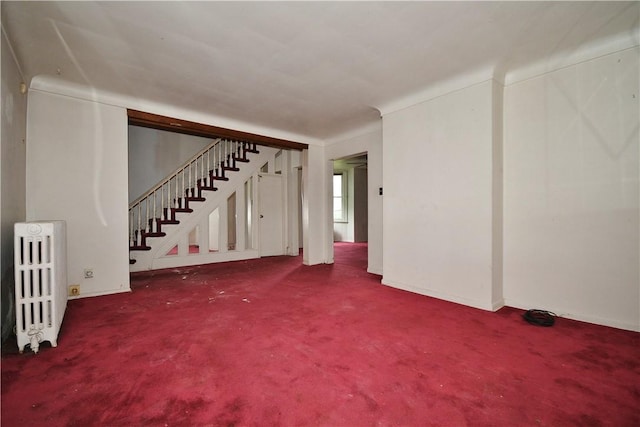 4605 2nd St, Versailles Boro, PA 15132 - unfurnished living room featuring radiator heating unit, stairway, carpet flooring, and baseboards