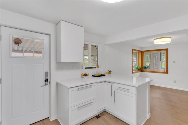 9830 Don Dr, North Huntingdon, PA 15642 - kitchen with a peninsula, light countertops, white cabinets, and light wood-style floors