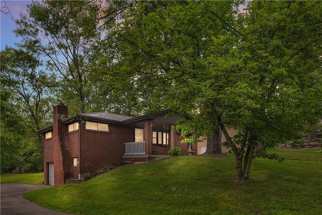 9830 Don Dr, North Huntingdon, PA 15642 - view of front facade featuring a chimney, an attached garage, asphalt driveway, a front yard, and brick siding