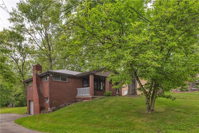 9830 Don Dr, North Huntingdon, PA 15642 - view of front facade with a chimney, brick siding, a front lawn, driveway, and an attached garage
