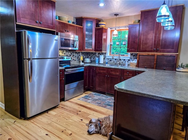 277 Dunn Rd, Hempfield Twp Wml, PA 15601 - kitchen with stainless steel appliances, dark brown cabinets, a sink, light wood finished floors, and decorative backsplash