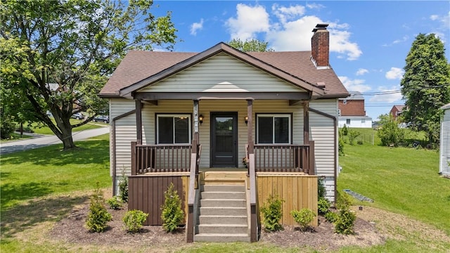 707 Hamil Rd, Penn Hills, PA 15147 - bungalow-style home with covered porch, a front yard, a chimney, and a shingled roof