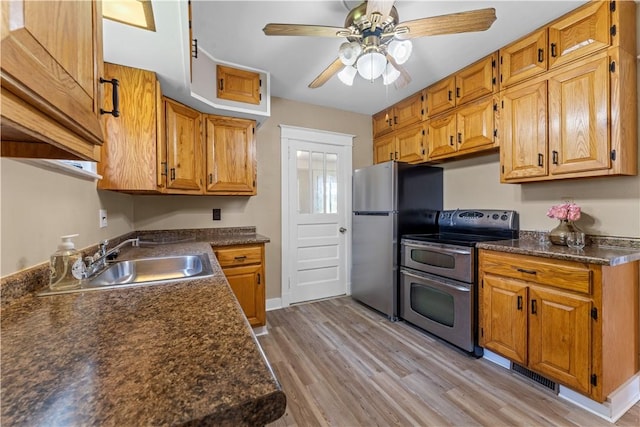 707 Hamil Rd, Penn Hills, PA 15147 - kitchen featuring appliances with stainless steel finishes, dark countertops, a ceiling fan, and light wood-style floors