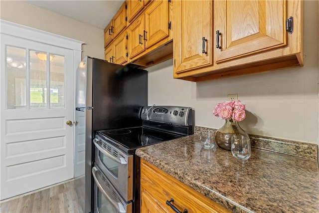 707 Hamil Rd, Penn Hills, PA 15147 - kitchen with range with two ovens, light wood finished floors, brown cabinets, and dark stone counters