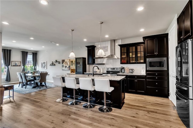 305 Tillary Ln Unit 202, Cranberry Twp, PA 16066 - kitchen featuring stainless steel appliances, wall chimney range hood, a sink, tasteful backsplash, and a kitchen bar