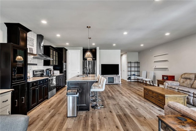 305 Tillary Ln Unit 202, Cranberry Twp, PA 16066 - kitchen with appliances with stainless steel finishes, open floor plan, wall chimney range hood, a breakfast bar area, and light wood-style floors