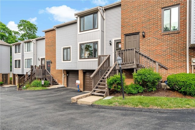 303 Serendipity Dr, Moon/Crescent Twp, PA 15108 - view of front of home with stairs, brick siding, a garage, and asphalt driveway