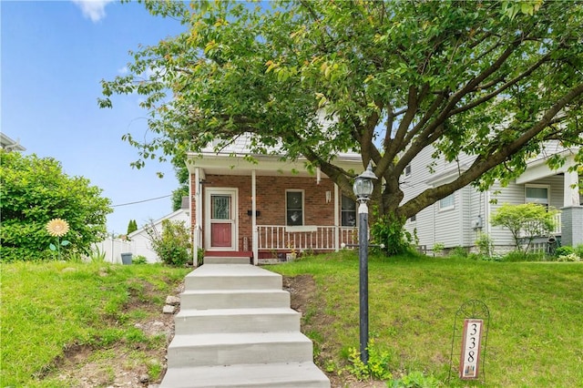 338 Buffalo St, Beaver, PA 15009 - view of front of house featuring brick siding, a porch, and a front lawn