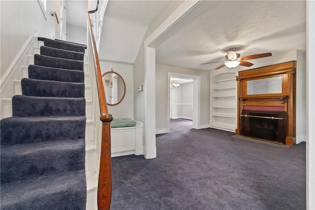 338 Buffalo St, Beaver, PA 15009 - unfurnished living room featuring ceiling fan, dark colored carpet, stairs, built in features, and a brick fireplace