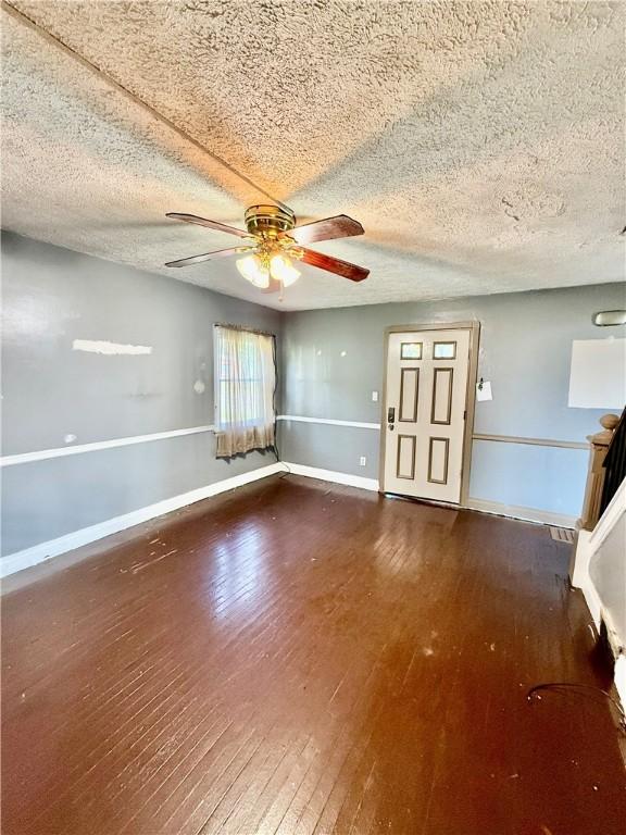 210 Griscom St, Dawson, PA 15428 - unfurnished living room with hardwood / wood-style floors, a ceiling fan, baseboards, and a textured ceiling