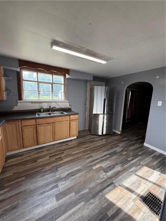 210 Griscom St, Dawson, PA 15428 - kitchen featuring freestanding refrigerator, a sink, arched walkways, dark countertops, and dark wood-type flooring