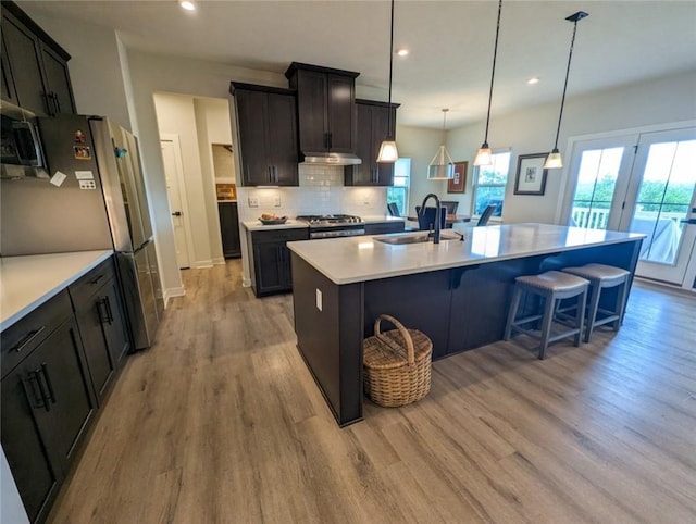137 Red Horse Dr, Buffalo Twp But, PA 16055 - kitchen featuring stainless steel appliances, a sink, an island with sink, light wood-type flooring, and decorative backsplash