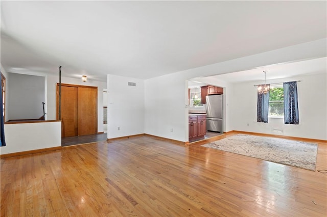 455 Darrell Dr, Penn Hills, PA 15235 - unfurnished living room featuring a chandelier, light wood finished floors, and baseboards