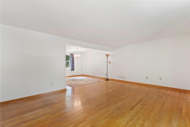 455 Darrell Dr, Penn Hills, PA 15235 - empty room featuring a chandelier, light wood-style flooring, and baseboards