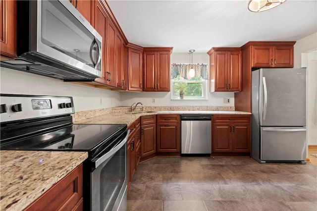 455 Darrell Dr, Penn Hills, PA 15235 - kitchen featuring appliances with stainless steel finishes, a sink, decorative light fixtures, light stone counters, and brown cabinetry