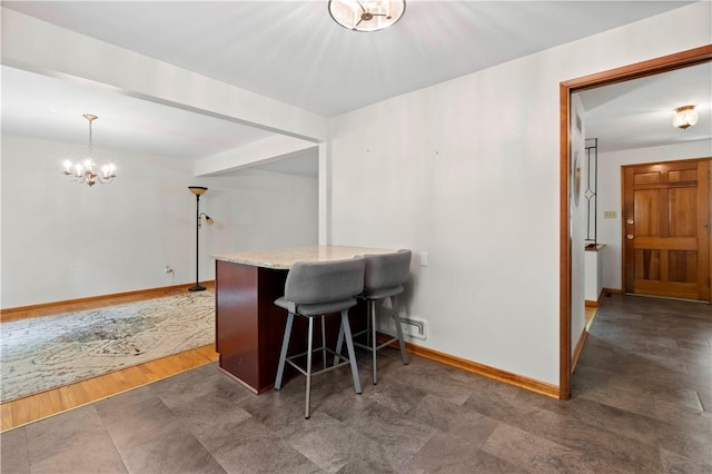 455 Darrell Dr, Penn Hills, PA 15235 - kitchen with baseboards, a chandelier, light stone counters, a kitchen bar, and decorative light fixtures