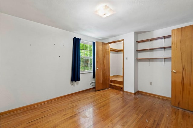 455 Darrell Dr, Penn Hills, PA 15235 - unfurnished bedroom featuring light wood-style floors, baseboards, a closet, and a baseboard heating unit