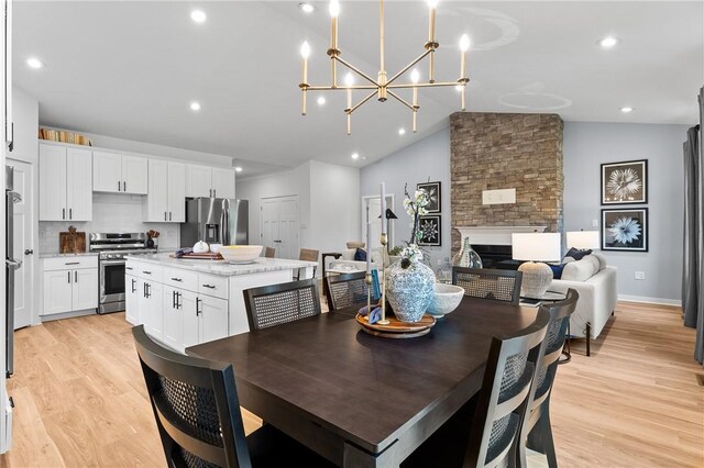 168 Twin Oaks Dr, Buffalo Twp, PA 16055 - dining area with light wood-type flooring, a chandelier, a fireplace, recessed lighting, and high vaulted ceiling