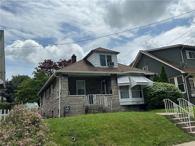 1810 Ridge Ave, Arnold, PA 15068 - bungalow featuring a chimney, stone siding, a front lawn, a shingled roof, and cooling unit