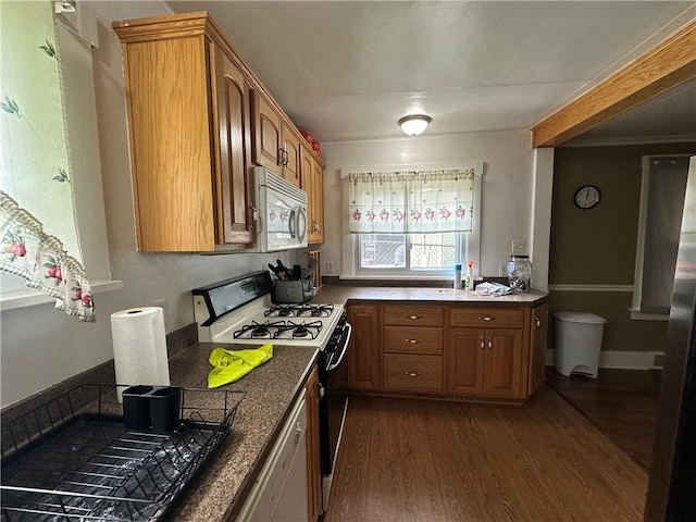 1810 Ridge Ave, Arnold, PA 15068 - kitchen featuring gas range oven, white microwave, dark wood-style floors, brown cabinetry, and dark countertops