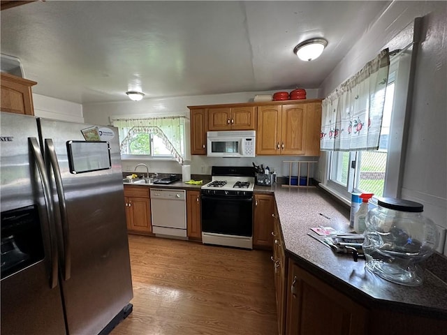 1810 Ridge Ave, Arnold, PA 15068 - kitchen with white appliances, light wood-type flooring, dark countertops, and brown cabinetry