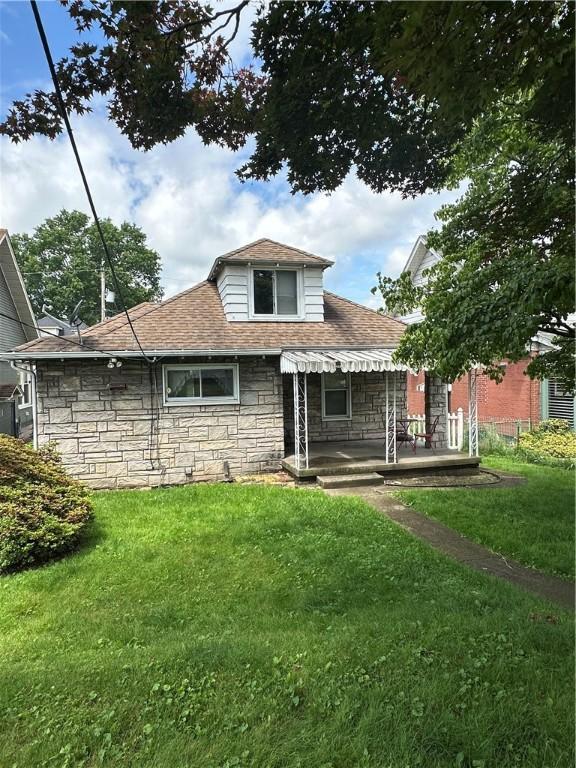 1810 Ridge Ave, Arnold, PA 15068 - bungalow-style home with stone siding, a front yard, and a shingled roof