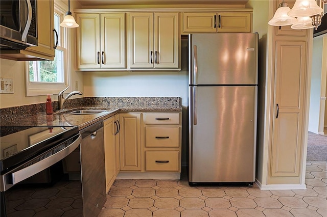 2678 Elaine Dr, Lower Burrell, PA 15068 - kitchen with appliances with stainless steel finishes, cream cabinetry, dark stone countertops, and hanging light fixtures
