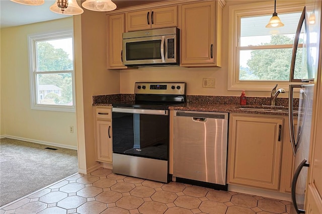 2678 Elaine Dr, Lower Burrell, PA 15068 - kitchen featuring appliances with stainless steel finishes, light colored carpet, dark stone counters, and hanging light fixtures