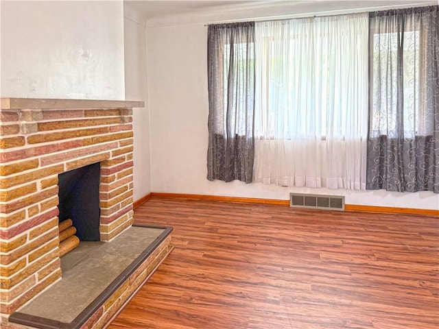 419 Washington Ave, Leechburg Boro, PA 15656 - unfurnished living room with wood finished floors, baseboards, and a brick fireplace