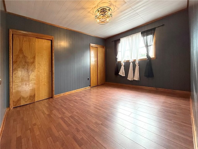419 Washington Ave, Leechburg Boro, PA 15656 - unfurnished bedroom featuring hardwood / wood-style floors, baseboards, ornamental molding, and wood walls