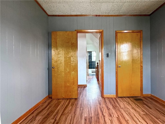 419 Washington Ave, Leechburg Boro, PA 15656 - empty room featuring crown molding, wood finished floors, baseboards, wooden walls, and an ornate ceiling