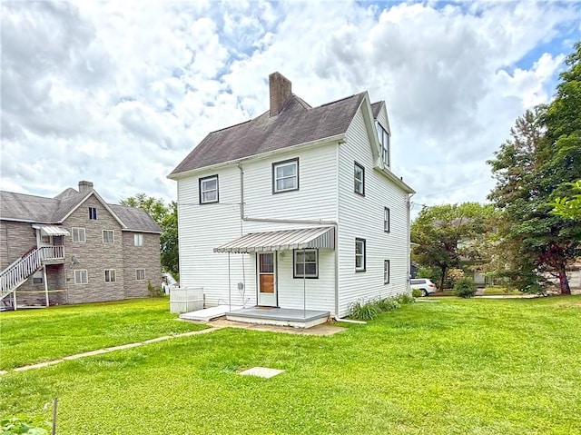 419 Washington Ave, Leechburg Boro, PA 15656 - rear view of property featuring a lawn and a chimney