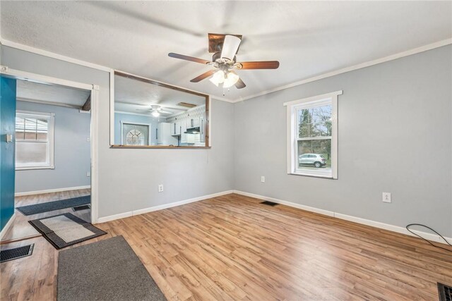 316 Dutchman Run Rd, Lower Burrell, PA 15068 - unfurnished room with plenty of natural light, wood finished floors, ceiling fan, baseboards, and crown molding