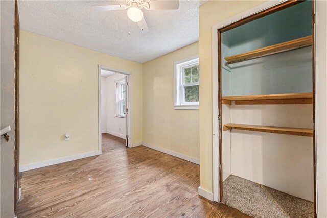 316 Dutchman Run Rd, Lower Burrell, PA 15068 - unfurnished bedroom featuring wood finished floors, baseboards, a textured ceiling, a closet, and a ceiling fan