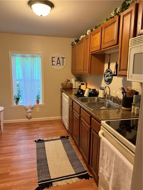 127 Tipple Row Rd, Hempfield Twp Wml, PA 15601 - kitchen featuring white appliances, a sink, light wood-style flooring, dark countertops, and brown cabinets
