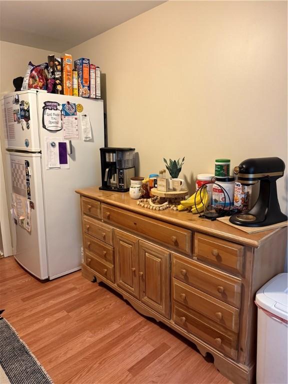 127 Tipple Row Rd, Hempfield Twp Wml, PA 15601 - kitchen featuring freestanding refrigerator, light wood-style flooring, light countertops, and brown cabinets