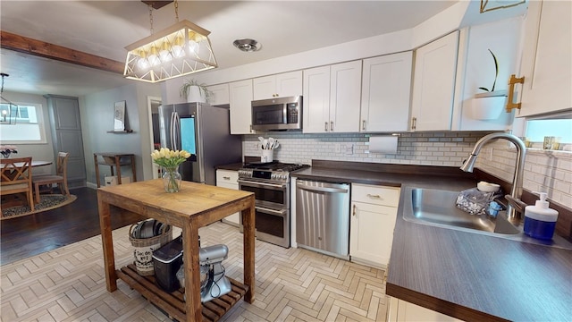 2819 Glenmore, Dormont, PA 15216 - kitchen featuring stainless steel appliances, dark countertops, tasteful backsplash, white cabinetry, and decorative light fixtures