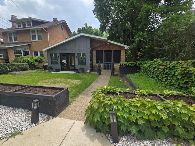 2819 Glenmore, Dormont, PA 15216 - back of property with french doors, a vegetable garden, board and batten siding, a yard, and brick siding