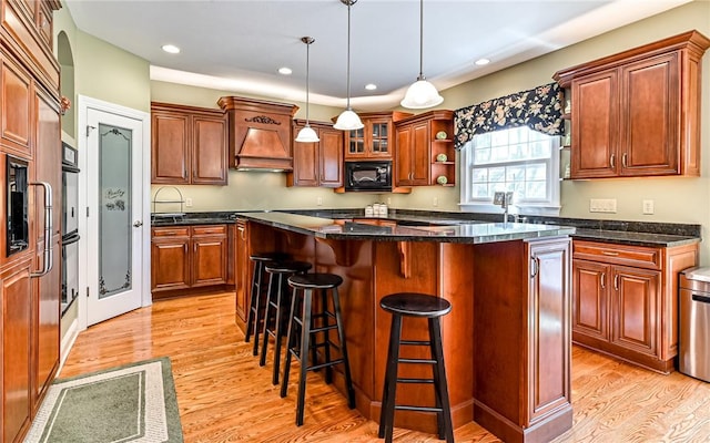 3124 Canterbury Dr, Hampton, PA 15101 - kitchen featuring light wood-type flooring, black microwave, a breakfast bar, a center island, and recessed lighting