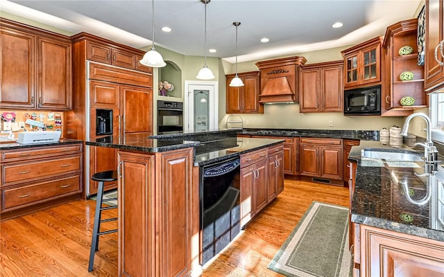 3124 Canterbury Dr, Hampton, PA 15101 - kitchen with a sink, black appliances, a center island, a breakfast bar, and light wood-style flooring