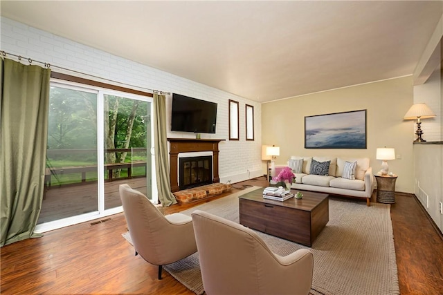 3131 Cheltenham Ct, Hampton, PA 15044 - living room featuring wood finished floors, a brick fireplace, brick wall, and baseboards