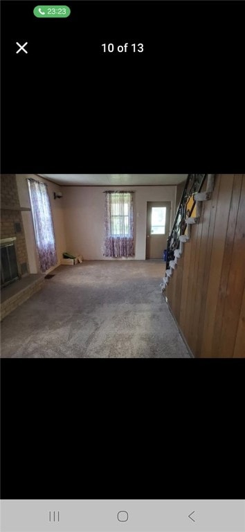 146 Back St, Quemahoning Twp, PA 15936 - basement with stairway, carpet floors, wood walls, and a brick fireplace