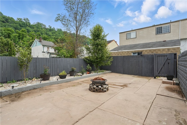 216 11th St, Sharpsburg, PA 15215 - fenced backyard with an outdoor fire pit, a patio area, and a gate