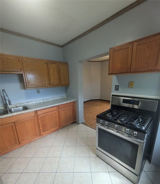 115 N Ray St, New Castle/3Rd, PA 16101 - kitchen featuring stainless steel gas range oven, a sink, brown cabinets, ornamental molding, and light countertops