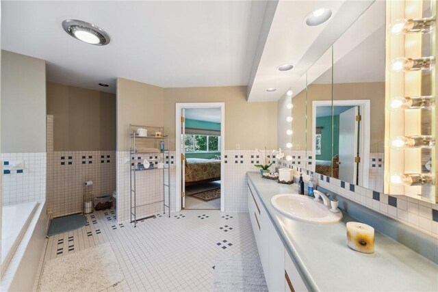 3532 Fairway Ct, Blairsville Area, PA 15717 - ensuite bathroom with tile walls, tile patterned flooring, vanity, a garden tub, and a wainscoted wall