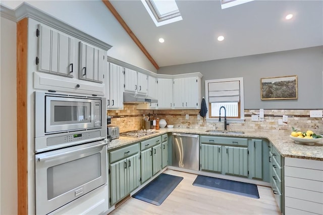 2971 Acre Rd, Scott Twp Law, PA 16101 - kitchen with appliances with stainless steel finishes, a sink, vaulted ceiling, under cabinet range hood, and decorative backsplash