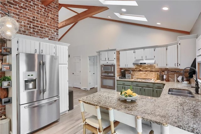 2971 Acre Rd, Scott Twp Law, PA 16101 - kitchen with stainless steel appliances, a sink, under cabinet range hood, a peninsula, and a skylight